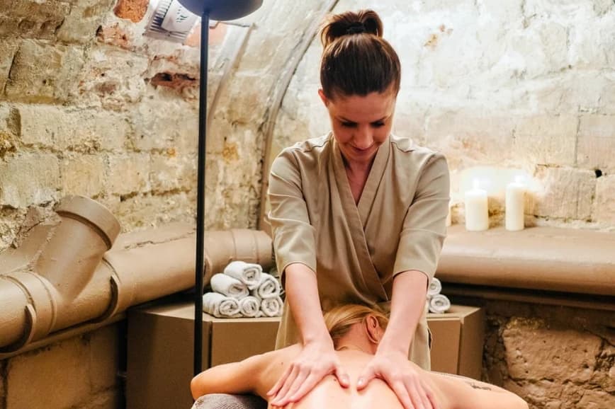 Elisa Willet pratique un massage du dos dans le cabinet aux murs de pierre.
