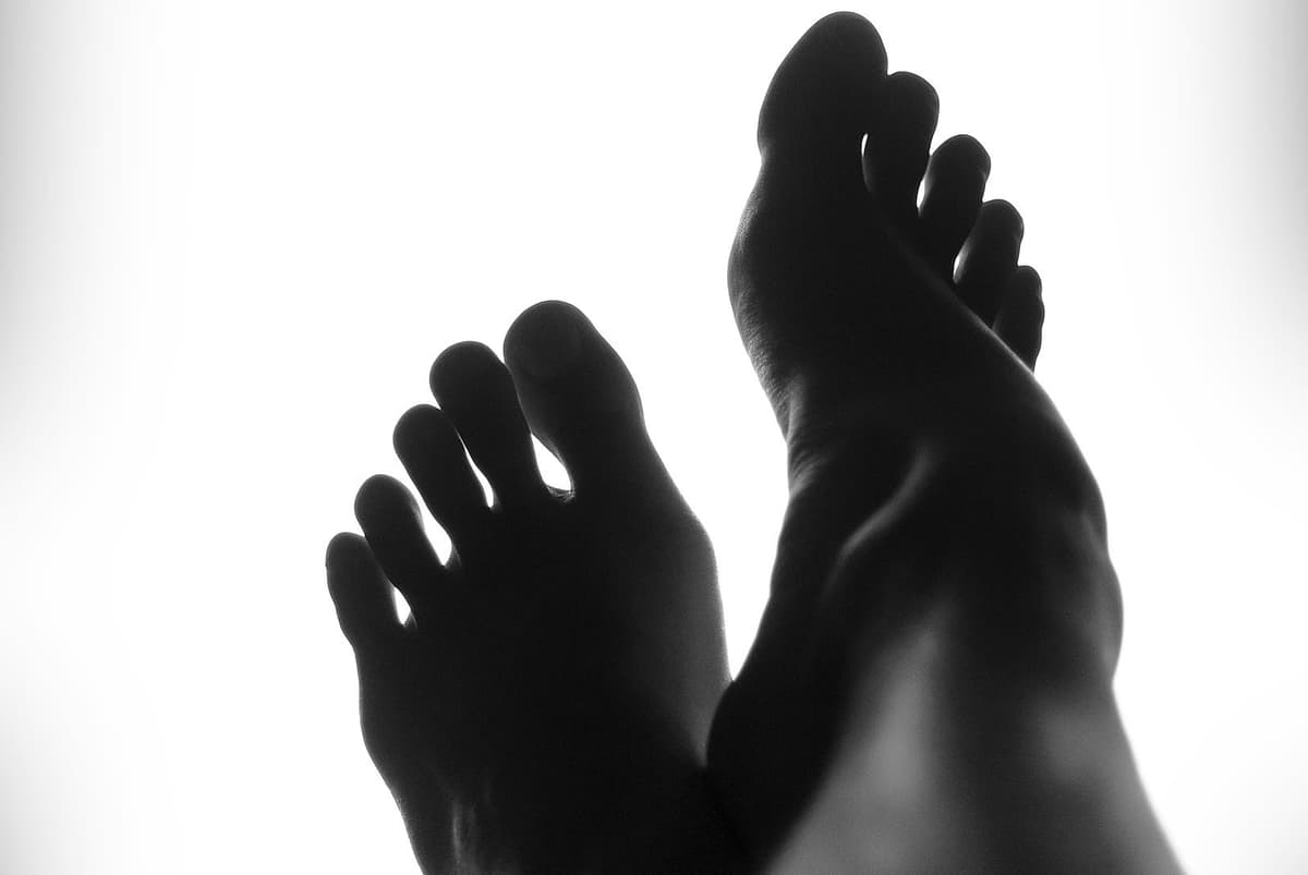 Deux pieds nus en contre-jour, en noir et blanc.